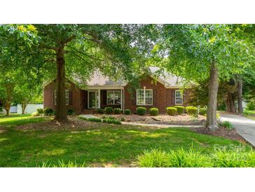 Charming red brick home featuring a well-maintained lawn and mature trees, enhancing curb appeal at 2005 Schofield Pl, Salisbury, NC 28144