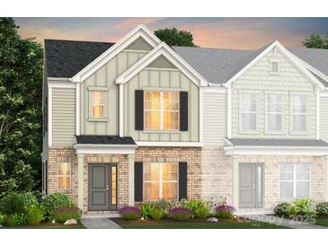 Charming two-story townhome with a brick facade, neutral siding, and manicured landscaping at 2119 Riverstone Blvd # 141, Monroe, NC 28110