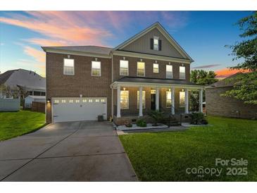 Charming brick home with a welcoming front porch, lush lawn, and two-car garage at 2213 Iron Works Dr, Clover, SC 29710