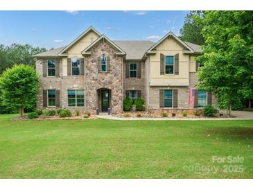 Stunning two-story brick home with a beautiful stone archway and manicured lawn at 240 Bells Crossing Dr, Mooresville, NC 28117