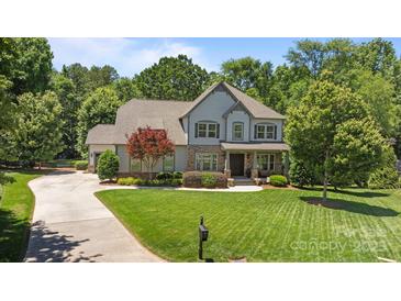 Charming two-story home with stone accents and a beautifully manicured lawn surrounded by mature trees at 3009 Botetourt Ct, Weddington, NC 28104