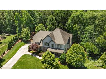Beautiful two-story home with a well-manicured lawn, mature trees, and elegant landscaping at 3009 Botetourt Ct, Matthews, NC 28104
