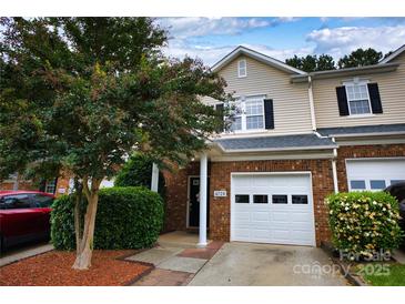Charming townhome featuring a brick facade, attached garage, and manicured landscaping at 4728 Cottage Oaks Dr, Charlotte, NC 28269