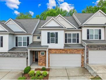 Charming townhome with a two-car garage and brick facade, complemented by beautiful landscaping at 4848 Fonthill Ln, Charlotte, NC 28210