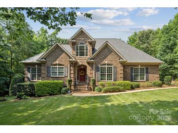 Beautiful brick home with manicured lawn, mature trees, and a welcoming front porch at 5812 Morgan Park Dr, Monroe, NC 28110
