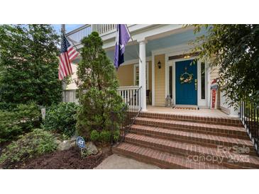 Charming home with a welcoming front porch, brick steps, and a vibrant blue door adorned with a wreath at 6129 Caseys Side Way, Fort Mill, SC 29708