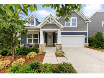 Charming home featuring a landscaped yard, inviting front porch, and a two-car garage at 6261 Six String Ct, Fort Mill, SC 29708