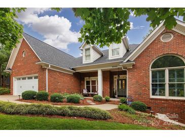 Beautiful brick home featuring manicured landscaping and a charming front porch with stately columns at 8008 Alba Ct, Charlotte, NC 28269