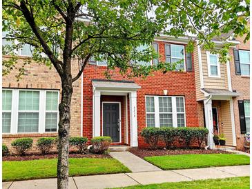 Charming two-story red brick townhouse with well-maintained landscaping and inviting front entrance at 8230 Viewpoint Ln, Cornelius, NC 28031