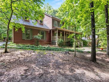 Charming two-story home featuring a full front porch and lush green surroundings at 10710 Bristlecone Ct, Mint Hill, NC 28227