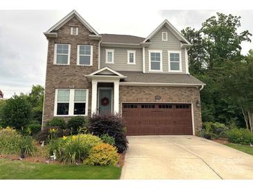Charming two-story home featuring a brick facade, well-manicured lawn, and a welcoming front entrance at 1124 Greenbridge Dr, Matthews, NC 28105