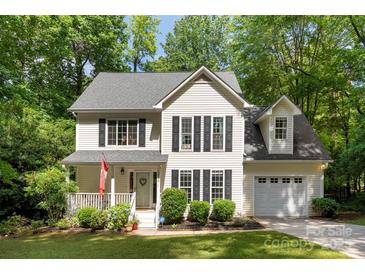 Charming two-story home boasts lush landscaping and a welcoming front porch at 116 Oak Creek Dr, Charlotte, NC 28270