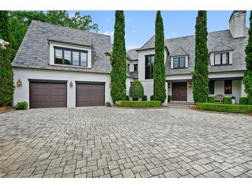 Elegant two-story home with a brick driveway, a two car garage, and beautiful landscaping at 11710 Ney Manor Way, Charlotte, NC 28277