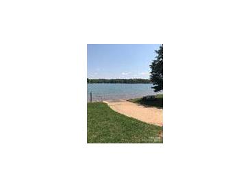 Scenic view of a lake with a sandy beach and clear blue water on a sunny day at 134 Crystal Cir, Mooresville, NC 28117