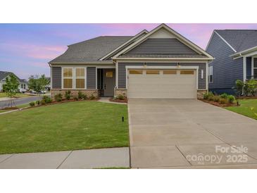 Charming home featuring a two-car garage, manicured lawn and neutral color palette at 1818 Winding Mist Dr, Belmont, NC 28012