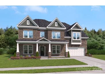 Charming two-story brick home with a well-manicured lawn, elegant dormers, and attached garage at 203 Balboa St, Matthews, NC 28104