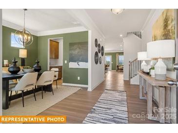 Inviting dining room featuring stylish chandelier, wood floors and abundant natural light at 5655 Arnold Way, Mount Pleasant, NC 28025