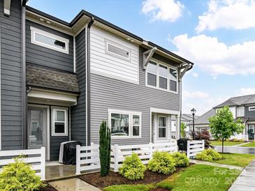Gray two-story townhouse featuring a white picket fence and meticulously maintained landscaping at 5811 Mantle Way, Kannapolis, NC 28081