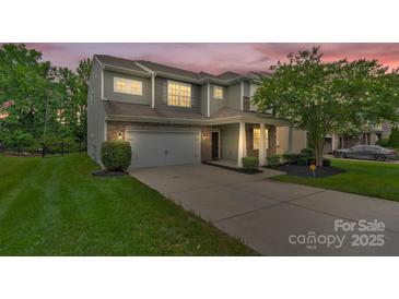 Two-story home shows inviting exterior with stone accents, landscaped front yard, and attached two-car garage at 7101 Agnew Dr, Charlotte, NC 28273