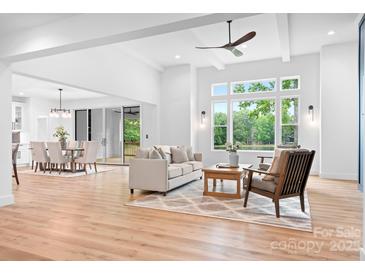 Spacious living room with an open floor plan and large windows showcasing lush greenery at 106 Arbor Dr, Waxhaw, NC 28173