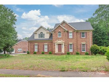 Charming two-story brick home featuring a well-manicured lawn and a classic architectural design at 114 Sardis Plantation Dr, Matthews, NC 28105