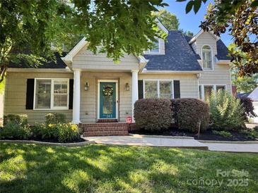 Charming home with a beautiful teal door and landscaped front yard, and inviting curb appeal at 141 Eastover Se Dr, Concord, NC 28025
