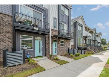 Charming townhome exterior with blue door and a small balcony on the second level at 235 S Bruns Ave, Charlotte, NC 28208