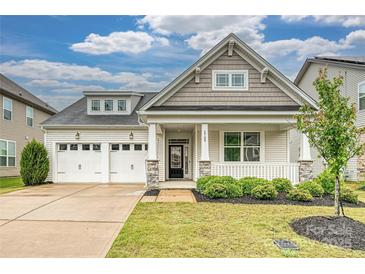 Charming home with a two-car garage, inviting front porch, manicured lawn, and appealing architectural details at 2760 Berkhamstead Cir, Concord, NC 28027