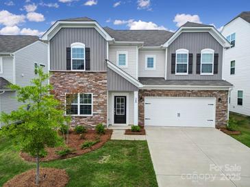 Charming two-story home with a stone facade, well-manicured lawn, and an attached two-car garage at 300 Kennerly Center Dr, Mooresville, NC 28115