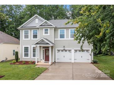 Charming two-story home with a well-manicured lawn and a two-car garage at 308 Planters Way, Mount Holly, NC 28120