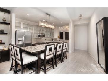 Modern kitchen featuring a center island with seating, stainless steel appliances, and a stunning chandelier at 333 W Trade St # 1304, Charlotte, NC 28202