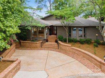 Inviting exterior showcases brick accents, mature trees, and a concrete driveway leading to the entrance at 449 Windward Dr, Davidson, NC 28036