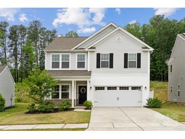 Charming two-story home with a manicured lawn, attached two-car garage, and inviting curb appeal at 5113 Saddleback Dr, Mount Holly, NC 28120