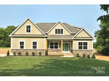 Charming home boasts a manicured lawn, stone accents, and a welcoming light blue front door at 5408 Unionville Brief Rd, Unionville, NC 28110