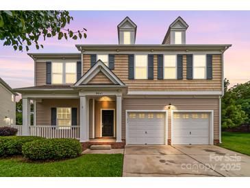 Charming two-story home features a manicured lawn, two-car garage, and inviting front porch at 9641 Bellamy Nw Pl, Concord, NC 28027