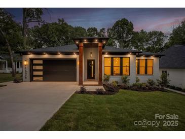 Charming single-story home boasting a well-manicured lawn, modern garage door, and inviting front entrance with decorative pillars at 1626 Burtonwood Cir, Charlotte, NC 28212