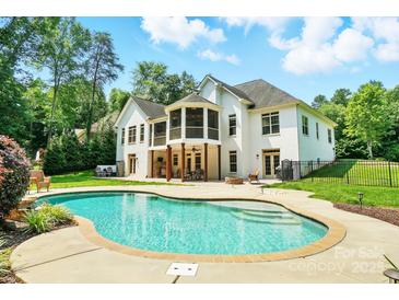 Beautiful backyard with in-ground pool, patio area, and a well-maintained white brick home at 167 Logan Crossing Dr, Davidson, NC 28036