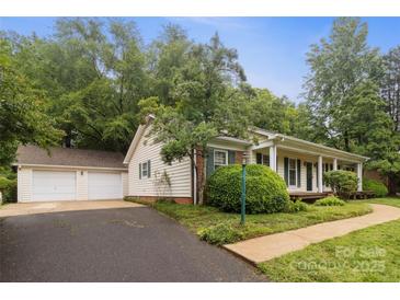 Charming home featuring a detached two-car garage and a well-maintained front yard at 1821 Bonnie Ln, Charlotte, NC 28213