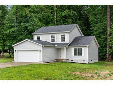 Charming two-story home with a gray exterior, attached garage, and lush green lawn at 2025 Slater Rd, Charlotte, NC 28216