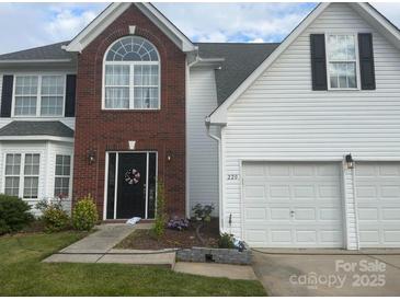 Charming two-story home featuring a brick facade, white siding, well-manicured lawn and a two car garage at 220 Otman Ct, Rock Hill, SC 29732