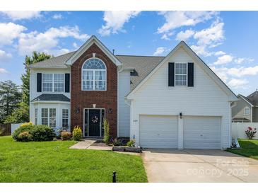 Charming home featuring a two-car garage, brick accents, a well-manicured lawn and inviting curb appeal at 220 Otman Ct, Rock Hill, SC 29732
