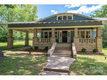 Charming blue home featuring a stone porch with inviting stairway and classic architectural details at 409 S Grove St, Lincolnton, NC 28092