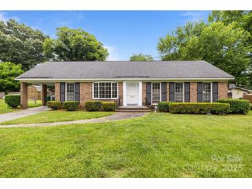 Charming brick home with manicured lawn, shutters and bright white front door at 5918 Barrington Dr, Charlotte, NC 28215
