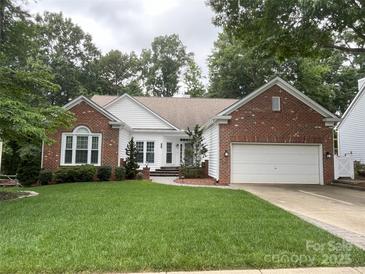 Beautiful single-Gathering home featuring brick and white siding, a well-manicured lawn, and attached two-car garage at 5929 Waterelm Ln, Charlotte, NC 28269