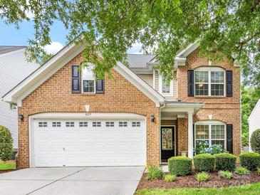 Charming two-story brick home featuring a two-car garage, manicured lawn, and beautifully landscaped front yard at 6619 Hermsley Rd, Charlotte, NC 28278
