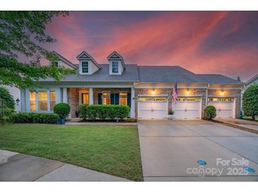 Charming brick home featuring a three-car garage, dormer windows, and professionally landscaped yard at 8725 Soaring Eagle Ln, Waxhaw, NC 28173