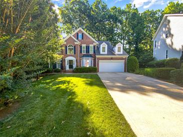 Charming two-story brick home featuring a well-manicured lawn and mature trees at 8803 Sweetwater Pl, Waxhaw, NC 28173