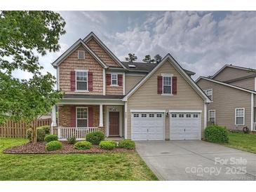 Charming two-story home with well-manicured lawn, attached two-car garage and inviting front porch at 9805 Coatbridge Dr, Charlotte, NC 28269