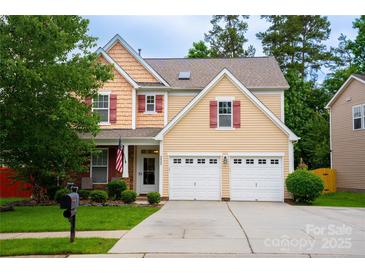 Charming two-story home featuring a manicured lawn, two-car garage, and inviting front porch with tasteful landscaping at 9805 Coatbridge Dr, Charlotte, NC 28269