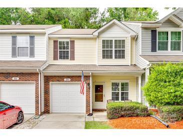 Inviting townhouse featuring a front-facing garage, manicured bushes, and a well-maintained lawn at 1003 Silver Spring Rd, Fort Mill, SC 29715